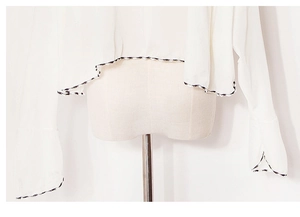 Close-up of contrast wavy stitching and split cuffs on a lightweight chiffon sun shawl
