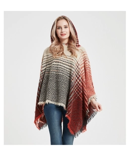 Detail of hooded poncho featuring fringe hem and vibrant orange geometric pattern