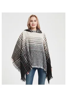Detailed view of women's hooded poncho featuring herringbone pattern and tassel fringe hem