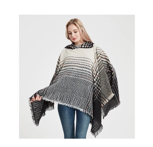 Close-up of knit hooded poncho showing herringbone patterns and tassel hem detail