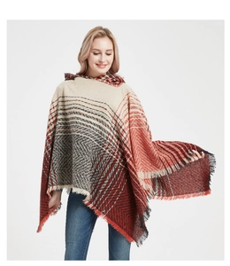 Detail of hooded knit poncho showing orange and black herringbone pattern and fringe edges