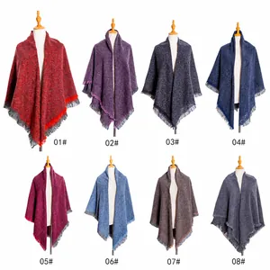 Detail showing various colors of thick knit grid square scarves with fringe tassels