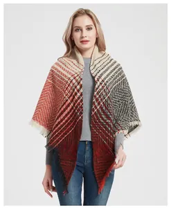 Close-up of geometric herringbone knit shawl with red orange grey tones and fringe trim