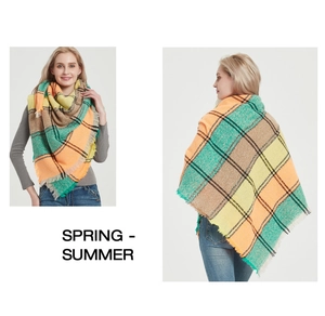 Detail of oversized multi-color plaid scarf featuring vibrant orange, green and yellow tones