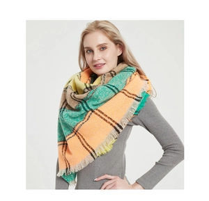Detail of colorful plaid scarf with soft knit texture and decorative fringe edges