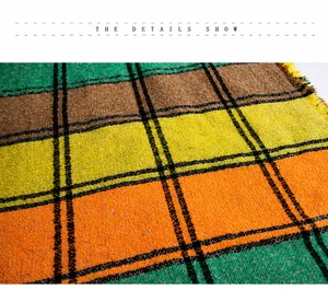 Detailed macro shot of thick knit plaid scarf fabric with orange and green colors