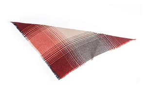Macro detail of herringbone knit shawl with red and grey tassels and stripes