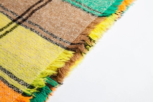 Close-up of thick checkered knit scarf showing colorful patterns and soft fringe details
