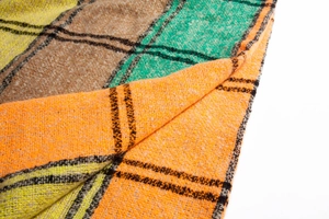 Close-up of thick plaid scarf fabric in vibrant orange green and yellow checks
