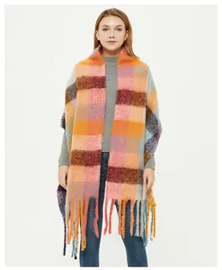 Close-up of thick multi-color plaid scarf with warm chunky knit texture and long tassels