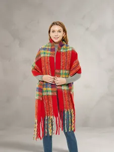 Dettaglio di sciarpa in maglia colorata con motivi scozzesi rossi e lunghe nappe a frange