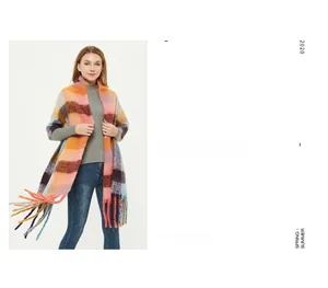 Detail of colorful plaid scarf with long fringe and thick knit texture for autumn winter