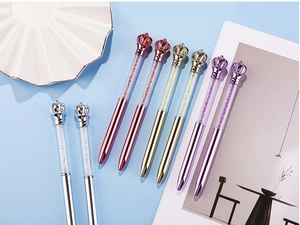 Detailed view of elegant crown crystal ballpoint pens in metallic rose gold and silver