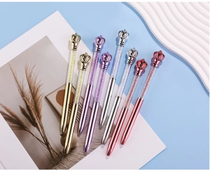 Detail of metallic crystal ballpoint pens with crown toppers in multiple colors
