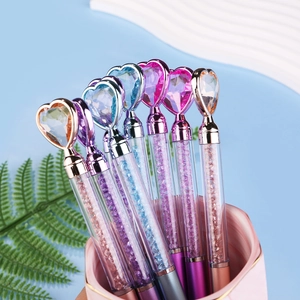 Detail of colorful crystal heart pens with liquid glitter inside a marble pen holder