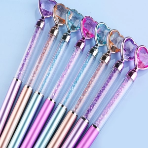 Macro detail of elegant diamond heart ballpoint pens with colorful crystal sand barrels