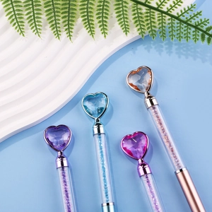 Close-up of heart-shaped crystal pens filled with colorful crushed rhinestones