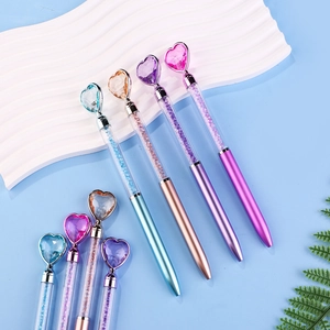 Close-up of heart crystal ballpoint pens with glitter sand and metallic finish