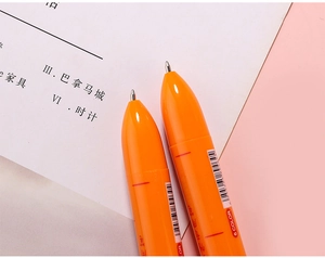 Detail of creative orange carrot-shaped ballpoint pen showing 6-color tip and plastic shell