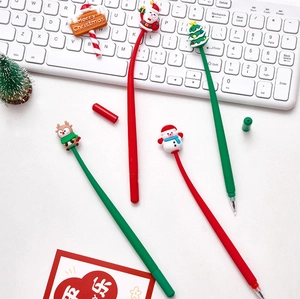 Close-up of Christmas silicone pens with Santa and snowman toppers on a white desk