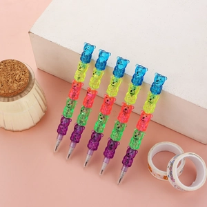 Five colorful bear-shaped stackable pencils set on a clean geometric display background