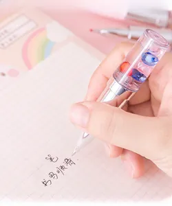 Close-up of creative lipstick-shaped pen with heart-shaped crystals held for writing