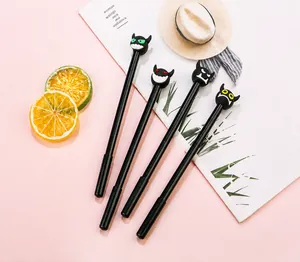 Set of four cute cartoon little devil gel pens with colorful emoji caps on a pink desk