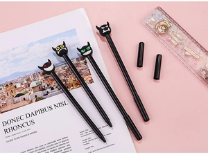 Detailed view of creative devil-themed gel pens with colorful silicone toppers on pink desk