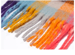 Macro detail of thick colorful checkered scarf with soft brushed texture and long tassels