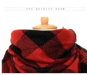 Close-up of soft cashmere-feel fabric showing red and black plaid pattern detail