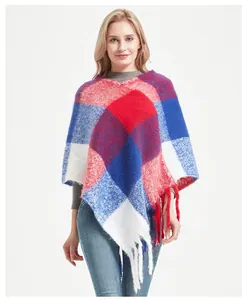 Detail of red and blue plaid poncho with fringe hem, showing thick knit texture and tassels