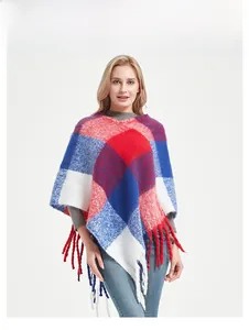 Detail of red and blue plaid poncho with long tassel fringe and thick knit texture