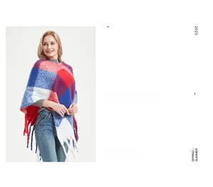 Detail of red and blue plaid poncho with thick braided tassels and knitted texture
