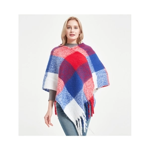 Detail of red and blue plaid knit poncho with soft texture and long tassel fringe trim