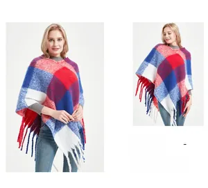 Close-up of thick knit plaid poncho featuring vibrant red and blue check patterns and long fringe