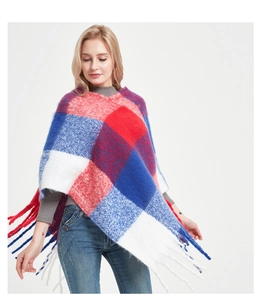 Close-up of red and blue checkered knit poncho with soft yarn fringe detail