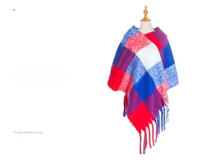 Close-up of thick knitted plaid poncho with red and blue checks and chunky fringe