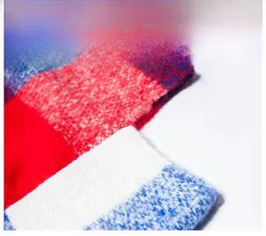 Macro shot of thick red and blue plaid knit fabric showing fuzzy texture and weave details