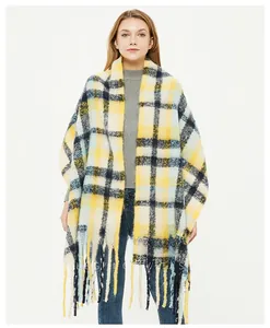 Detail of checkered scarf featuring yellow and blue plaid pattern with soft tassels