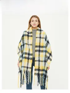 Detailed view of yellow and blue plaid scarf with long fringe tassels and thick knit texture