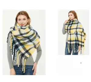 Detail of oversized ginger plaid scarf featuring thick tassels and mohair-like texture