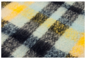 Macro shot of fluffy mohair texture with yellow and blue plaid pattern on winter scarf