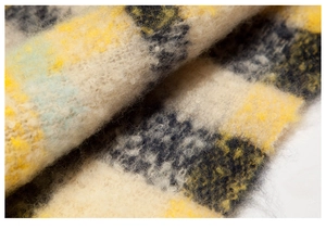 Macro shot of yellow and black checkered knit fabric with soft faux mohair texture