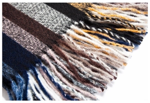 Primo piano di una sciarpa a righe multicolore con frange e morbida trama a maglia