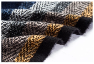 Vista macro di morbido tessuto a maglia a righe con nappe blu navy e senape