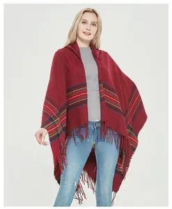Detail of red faux cashmere shawl with classic plaid patterns and long fringe tassels
