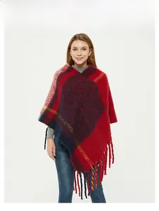 Close-up of red and blue plaid knit poncho with long tassels and yellow stripe details