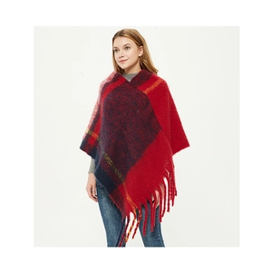 Detail of chunky fringed hem on thick plaid poncho wrap in red and navy knit