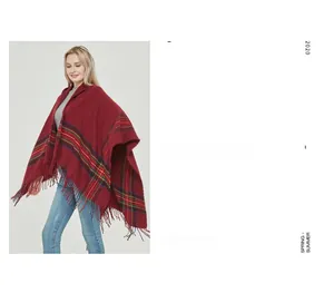 Detail of burgundy poncho featuring tartan check edges and fringe tassels on a white background