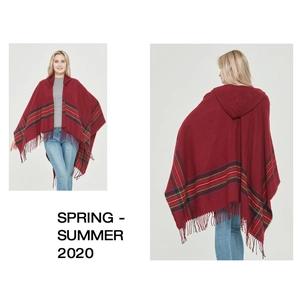Close-up of red knit hooded poncho with colorful stripes and long fringe details